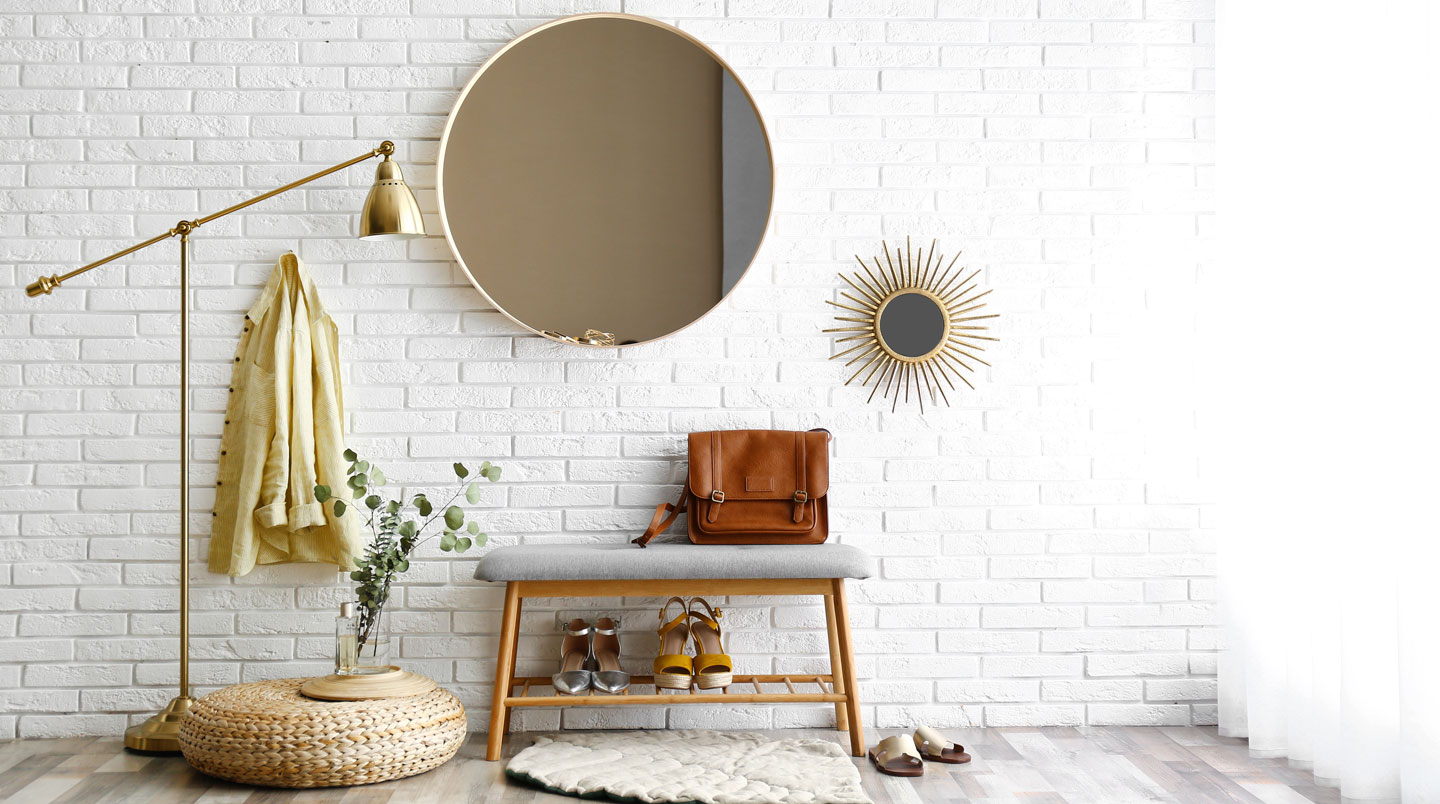 Salon en rez-de-chaussée aménagé avec murs blancs, miroirs et mobilier bas
